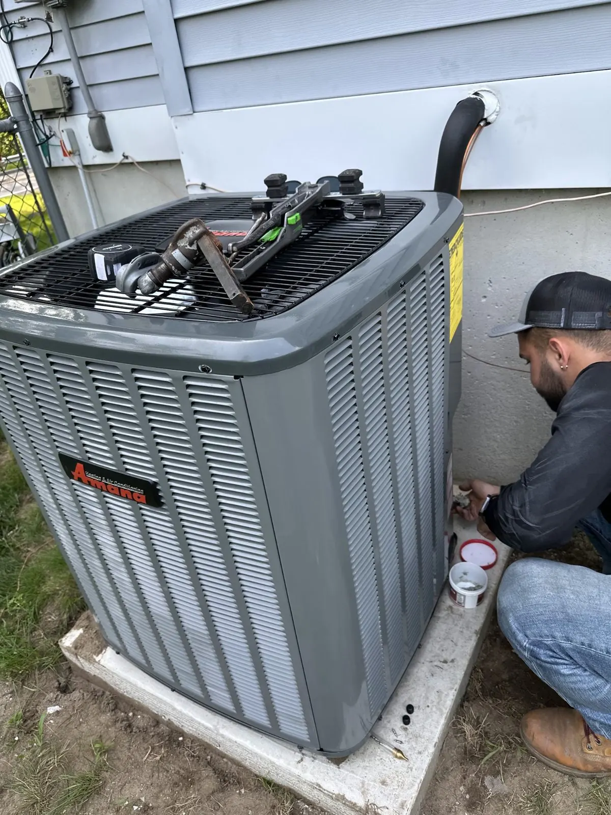 Technician servicing an outdoor air conditioner