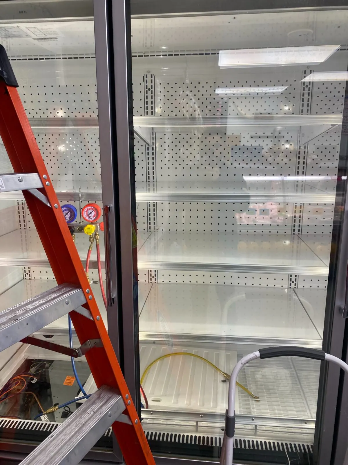 Commercial glass-door refrigerator during service