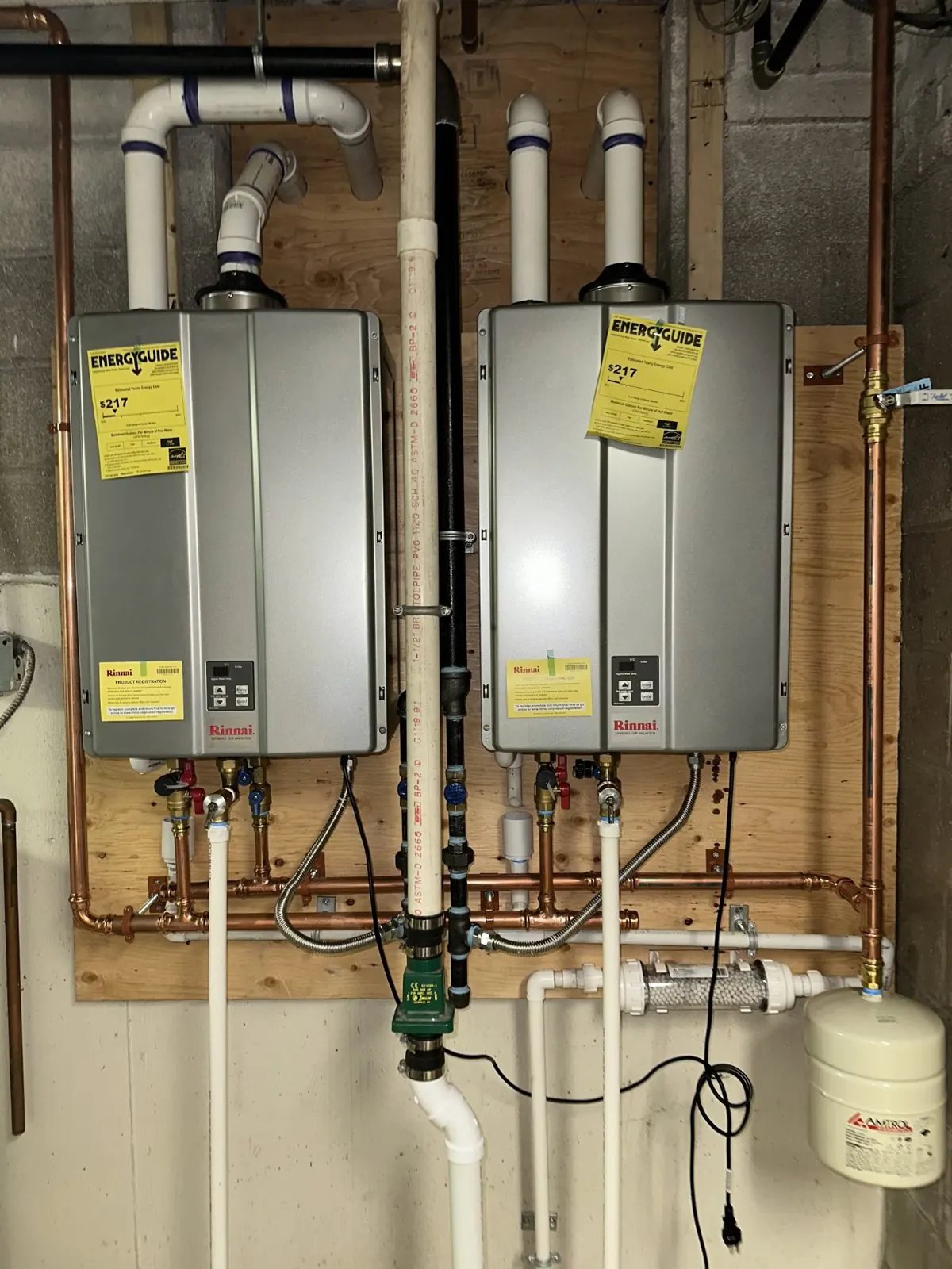 Two wall-mounted tankless water heaters with associated piping