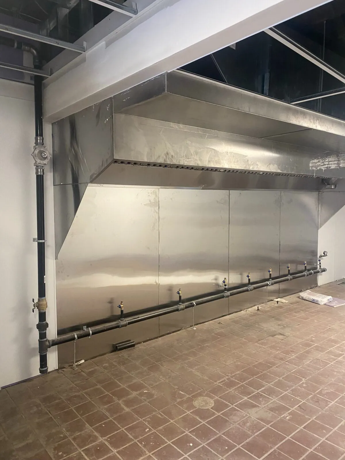 Full view of commercial kitchen gas piping under the hood