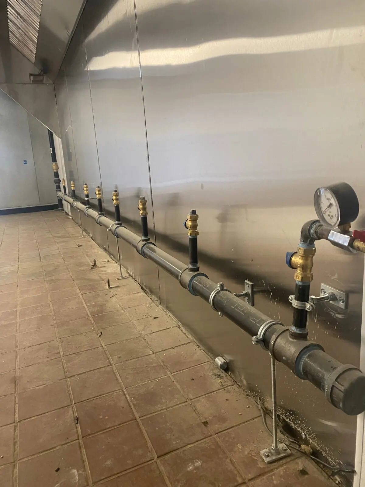 Commercial kitchen gas manifold with supports and pressure gauge