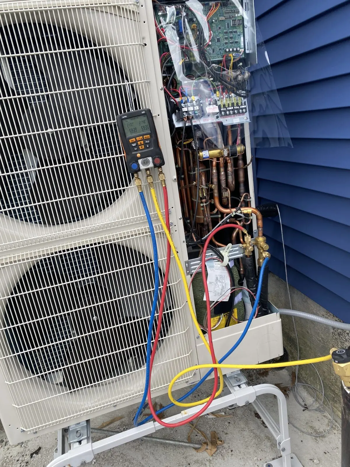 Outdoor unit with service panel open and gauges connected